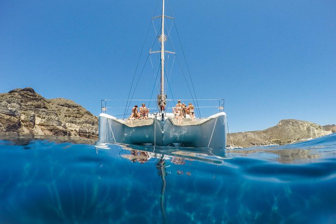 Santorini Catamaran Cruise with Fresh Meal and Open Bar - Red Beach, where the rock sets the tone