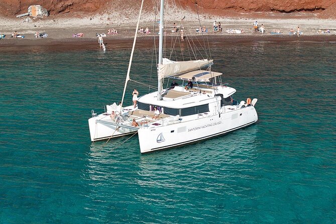 Santorini Catamaran Cruise: with Lunch, BBQ, Open Bar, Transfers - Red Beach: volcanic cliffs and the first swim