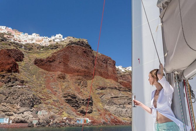 Santorini Private Catamaran Cruise with BBQ, Open Bar & Transfers - Indian Rocks, the lighthouse, and the caldera from below